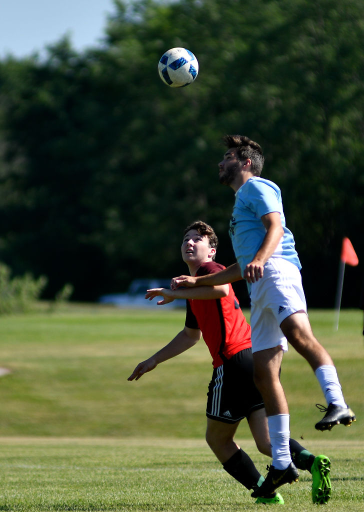 Jacob Rooney, 17, rises above Benny Greenley, 18, to head away an oncoming long pass